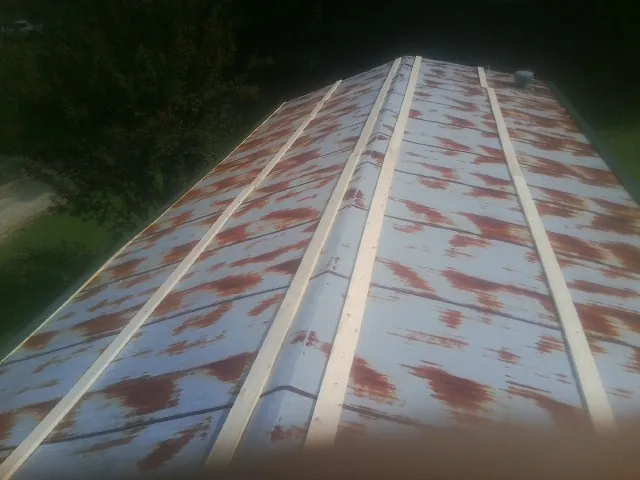 Rusted metal roof panels with new wood purlins before replacement — Storm Damage Roof Repair in Toledo by Roofing Brothers